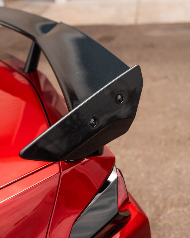 The rear wing of a red coupe