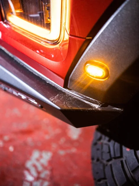 The lit amber lamp on the corner of a truck's bumper