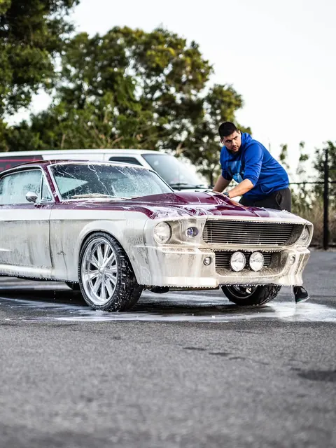 Wiping down the foamed hood of a classic fastback