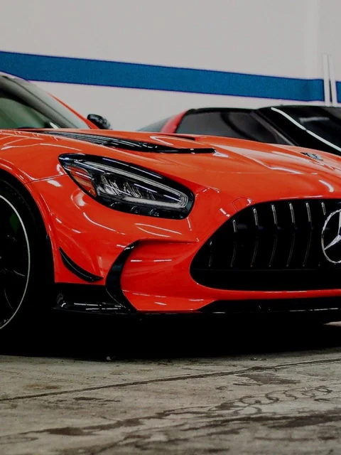 Front end of a red sports car on the shop floor