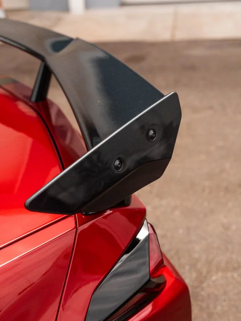 The rear wing of a red coupe